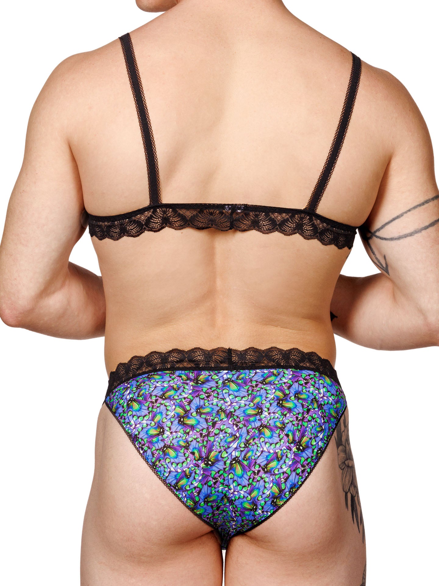 Male model wearing a blue floral print men's bralette with adjustable straps, lace trim, and a matching thong, shown from the back.