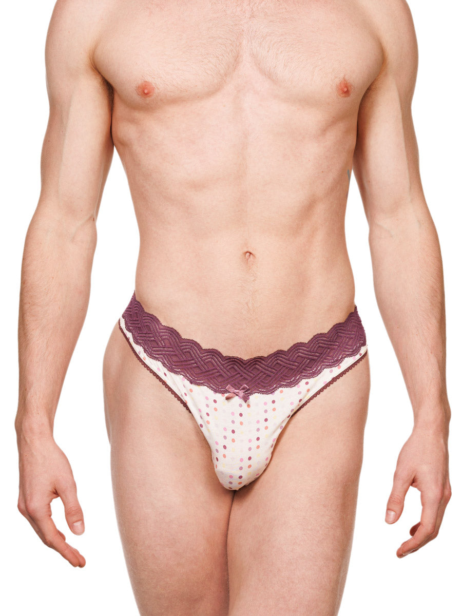 Front view of a male model wearing a white XDress cotton thong with polka dots and a burgundy waistband