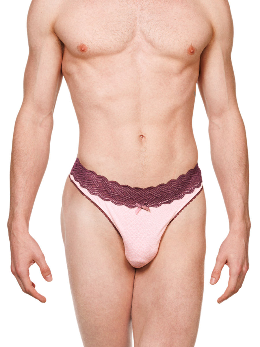 Front view of a male model wearing a pink XDress cotton thong with a red lace waistband