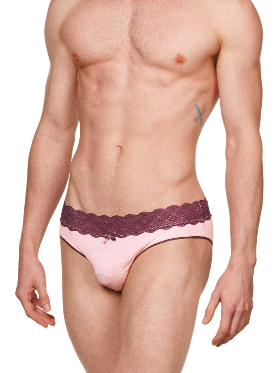 Side view of a male model wearing pink XDress cotton panties with a red lace waistband