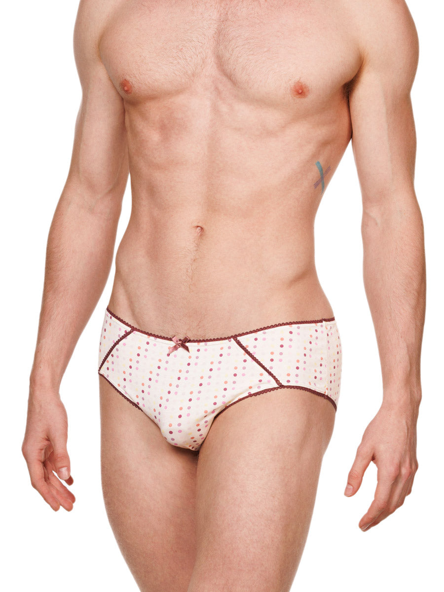 Side view of a male model wearing white XDress cotton panties with a polka dot pattern