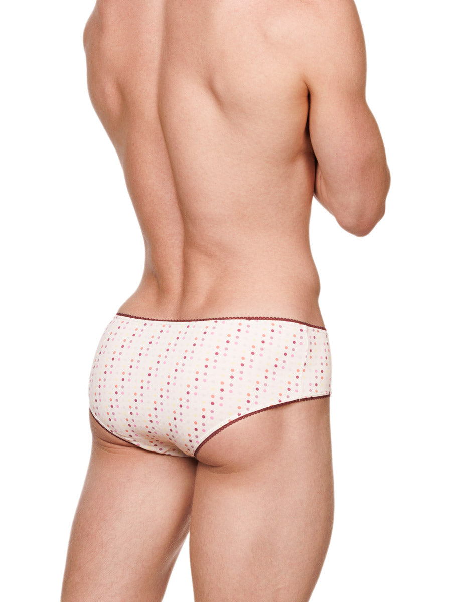 Side view of a male model wearing white XDress cotton panties with a polka dot pattern