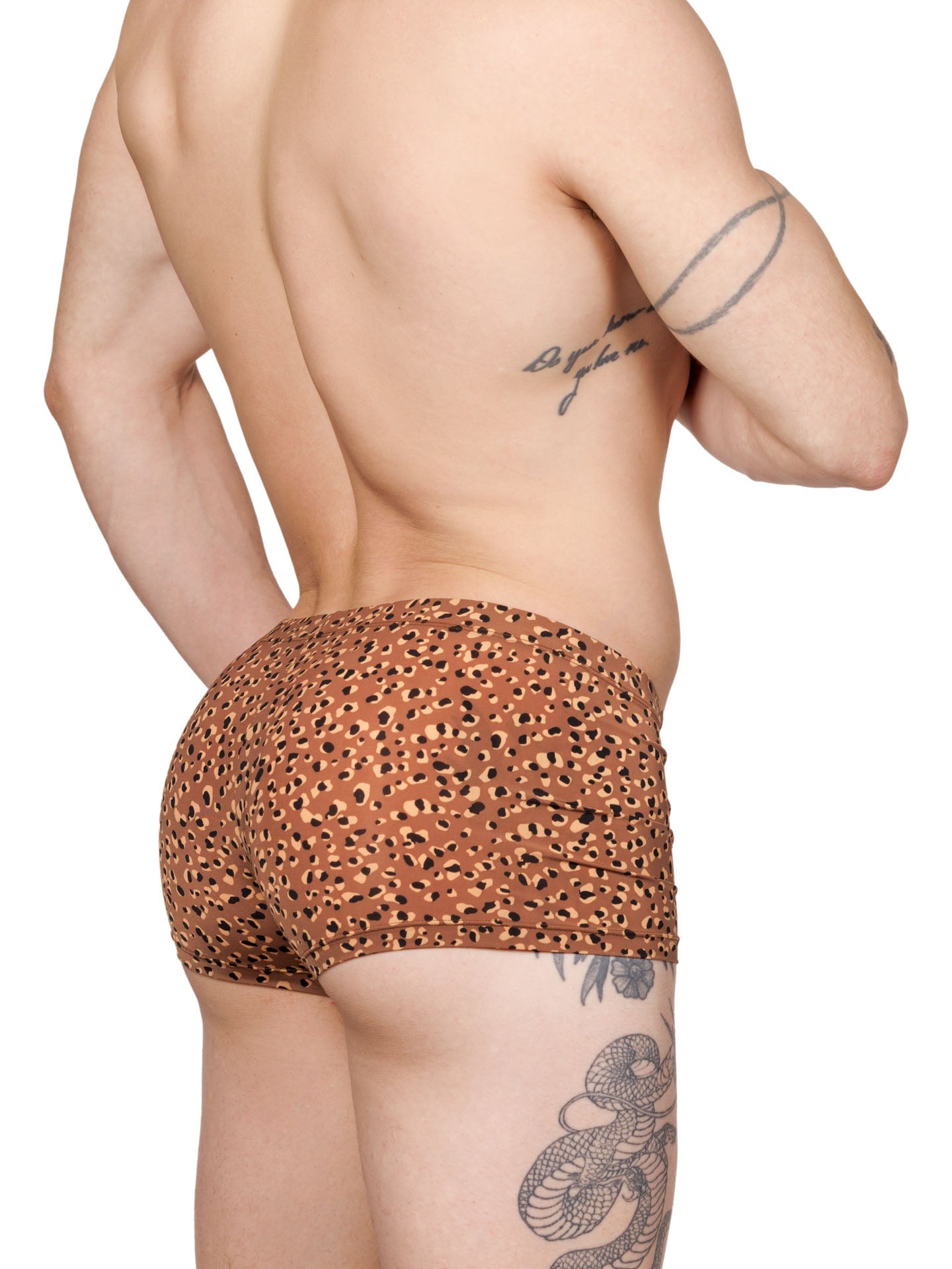 Side view of a male model wearing brown XDress boxer shorts with a leopard spot pattern