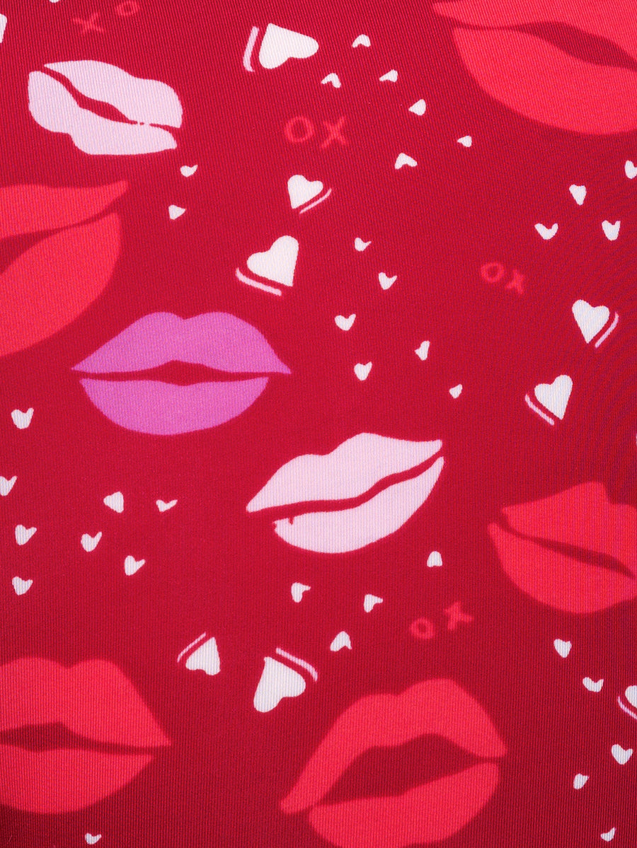 Closeup view of a multicolor lipstick kiss pattern on red fabric