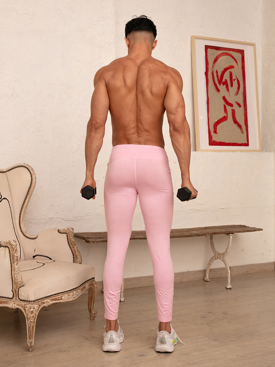 Rear view of a man wearing pink cotton leggings, holding dumbbells.