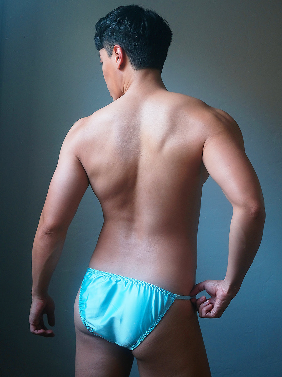 Back view of a male model wearing an XDress sky blue men's bikini brief