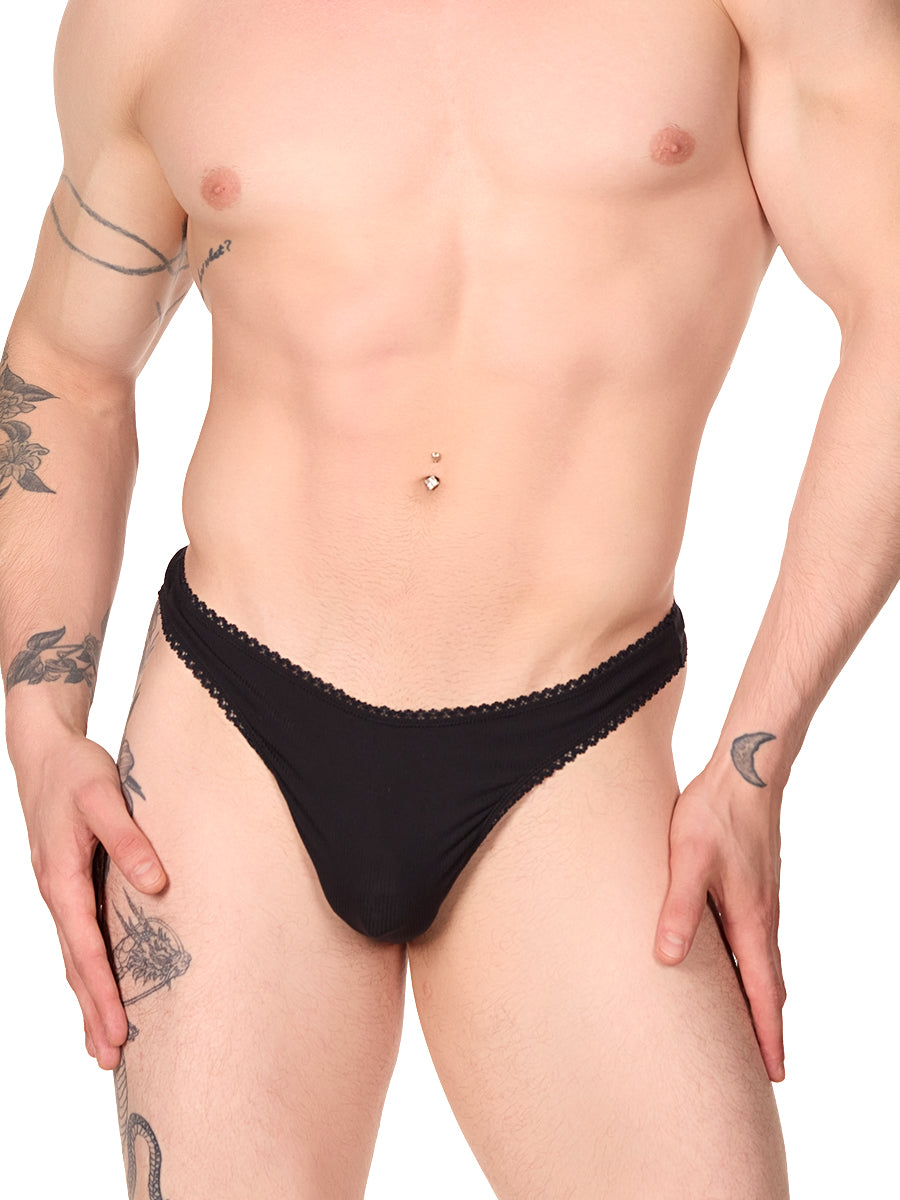 Front view of a man wearing a black XDress thong with lace trim