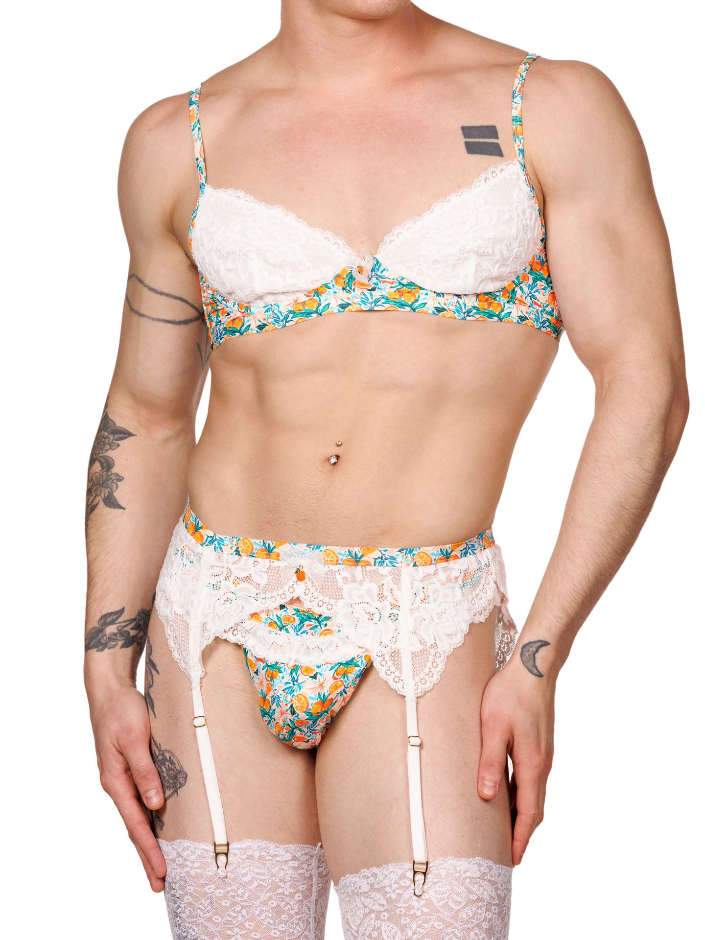 Front view of a male model wearing an XDress men’s bra and panty set with a vibrant orange blossom floral print and lace trim