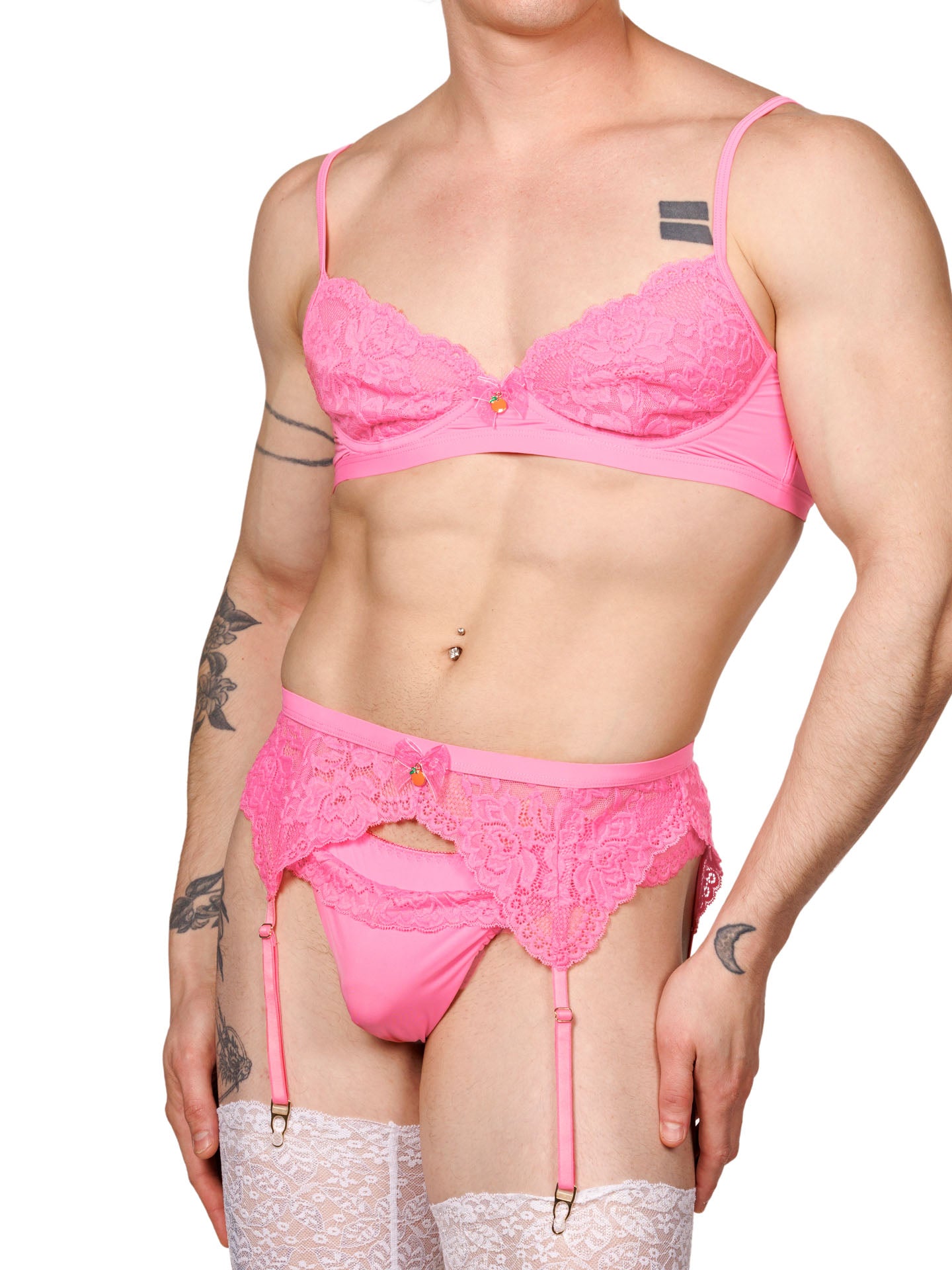 Front view of a male model wearing a pink lace bra, with a matching pink panty and garter belt.