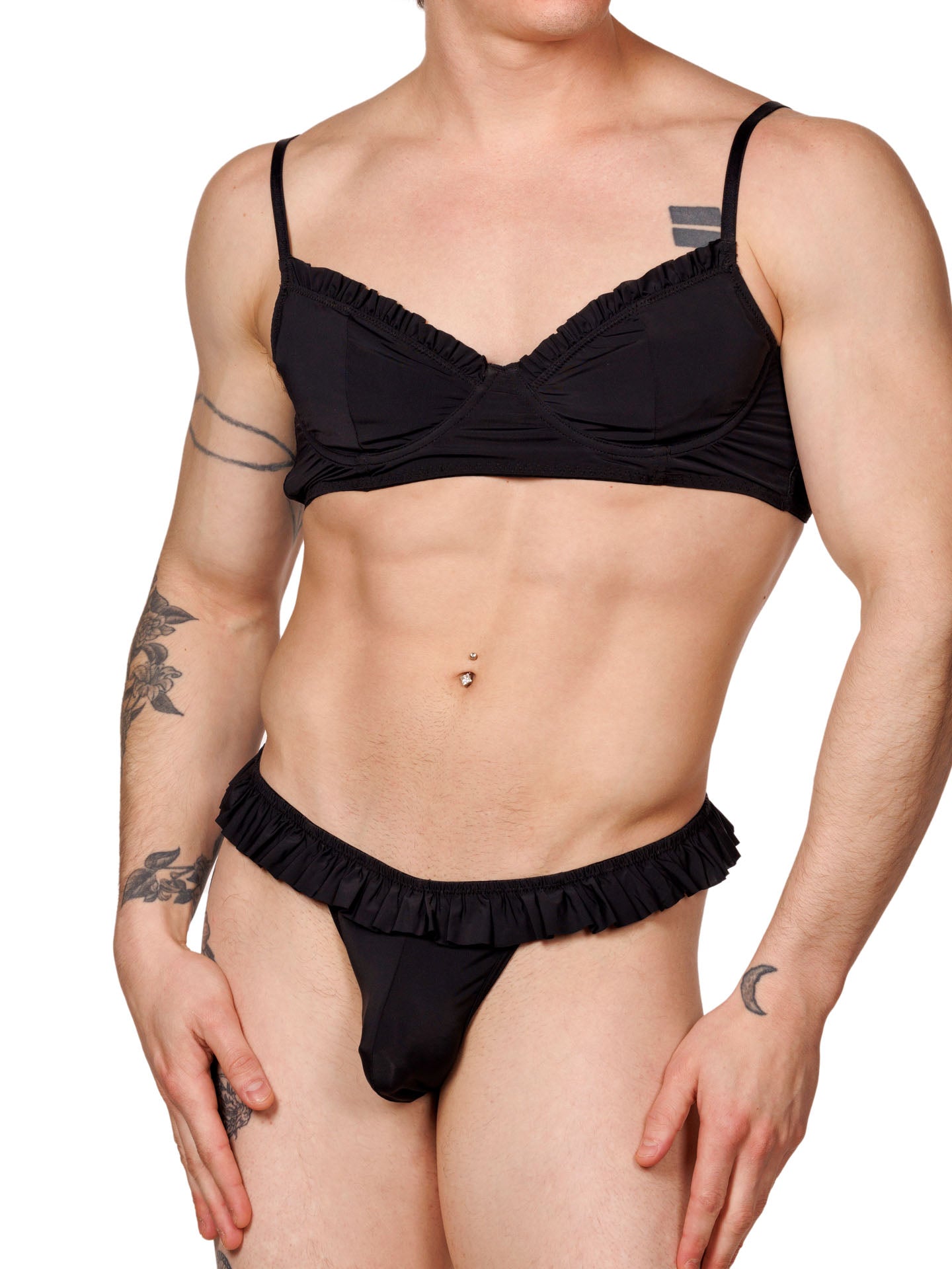 Front view of a male model wearing a matching black XDress bra and panty set with ruffles.