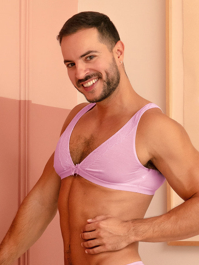 Side view of a man wearing a matching purple bra and panty set