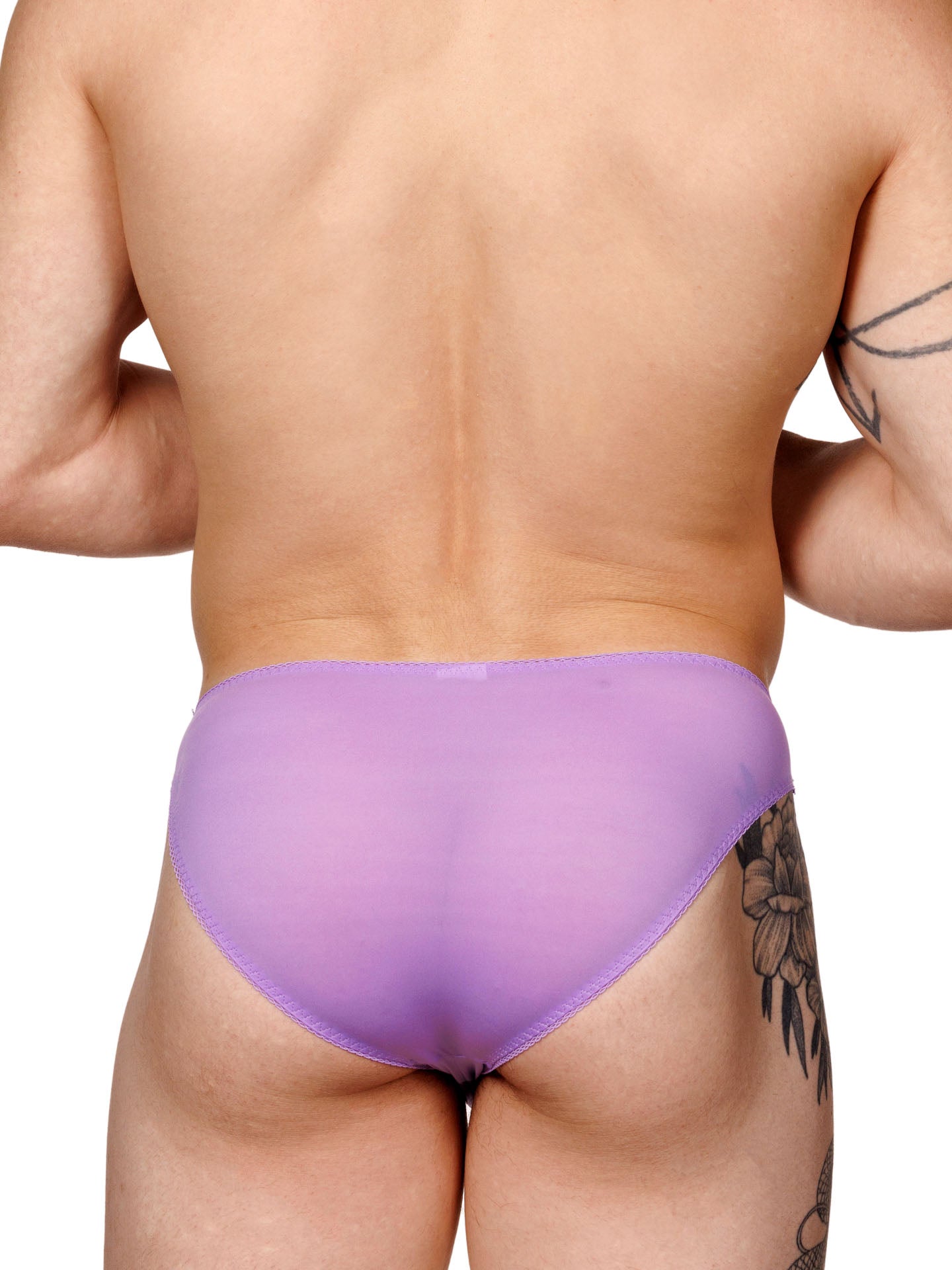 Male model wearing a purple men's panty with lace trim and a metallic charm at the front, shown from the back.