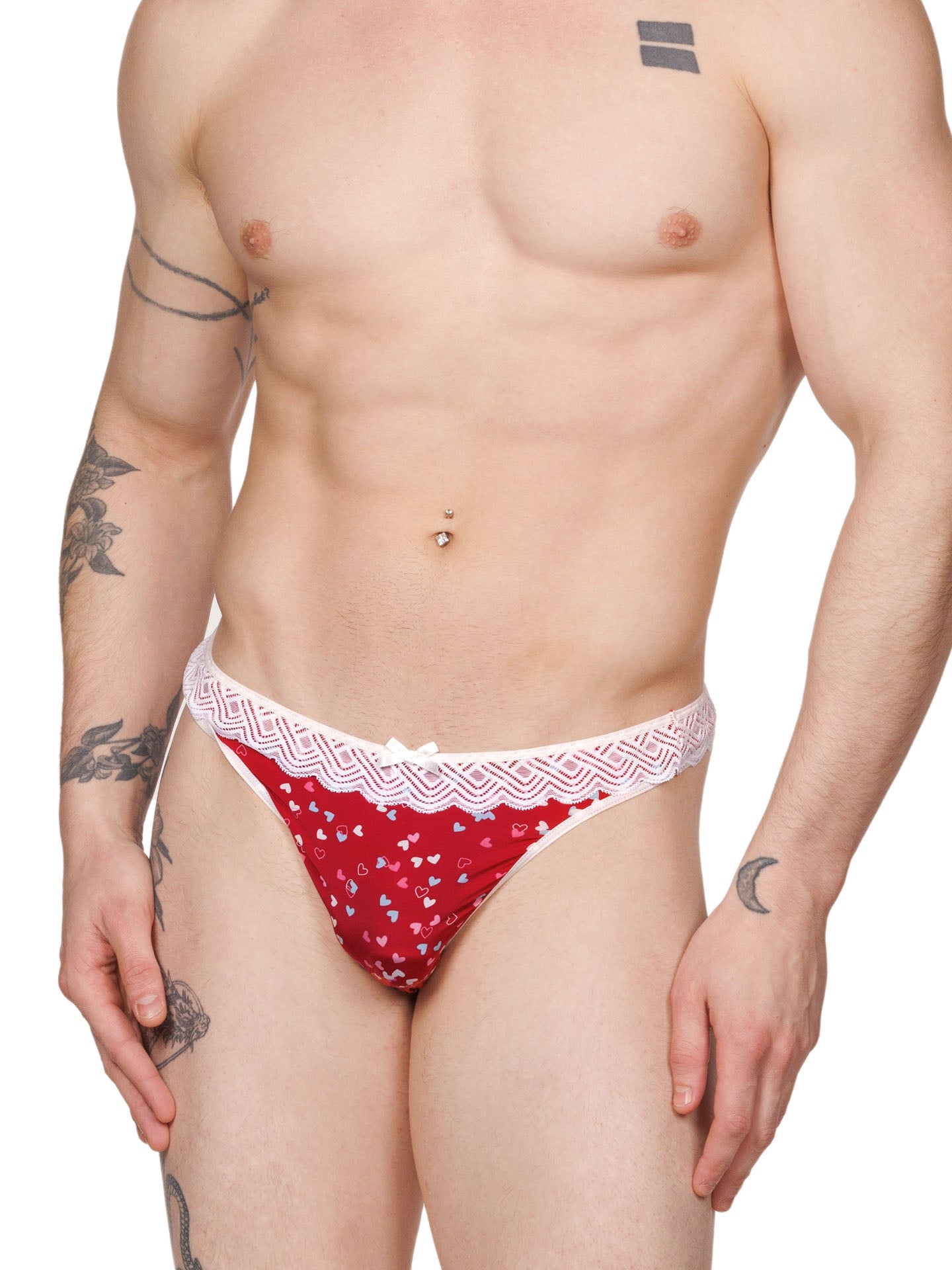 Front view of a male model wearing an XDress red and white thong with colored hearts pattern and lace waistband