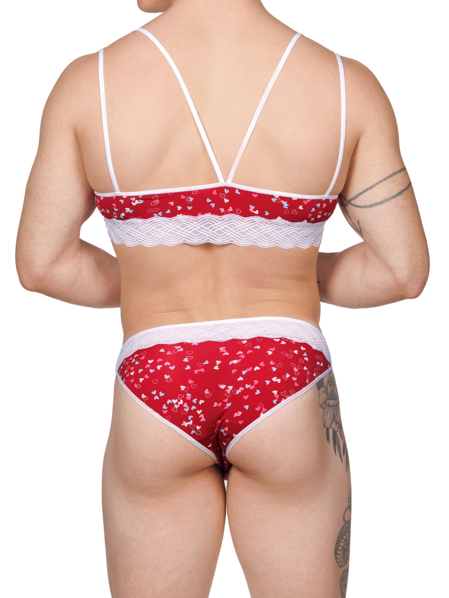 Back view of a male model wearing an XDress matching red men's panty and bra with white hearts pattern and lace waistband