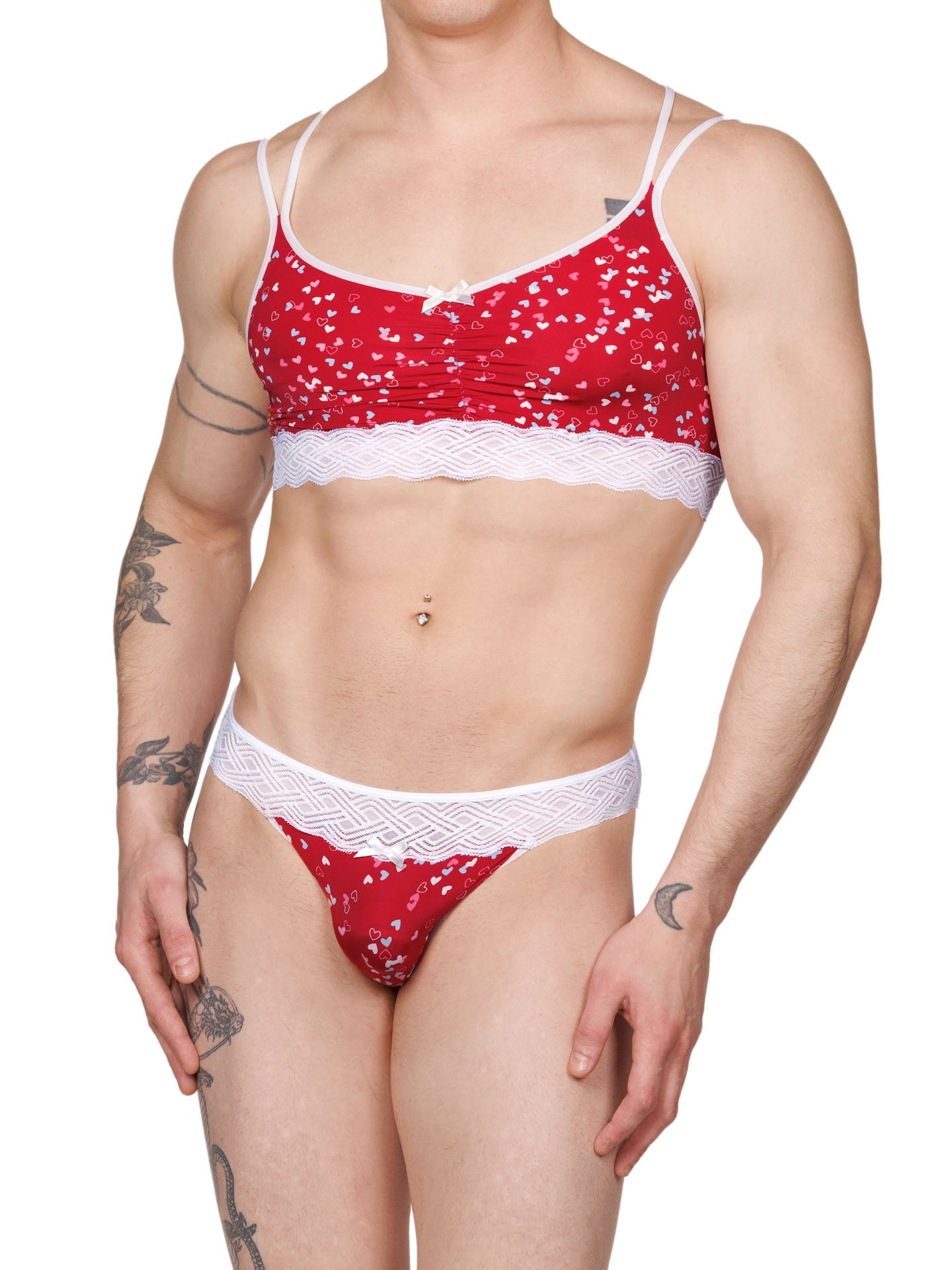 Front view of a male model wearing an XDress matching red men's panty and bra with white hearts pattern and lace waistband