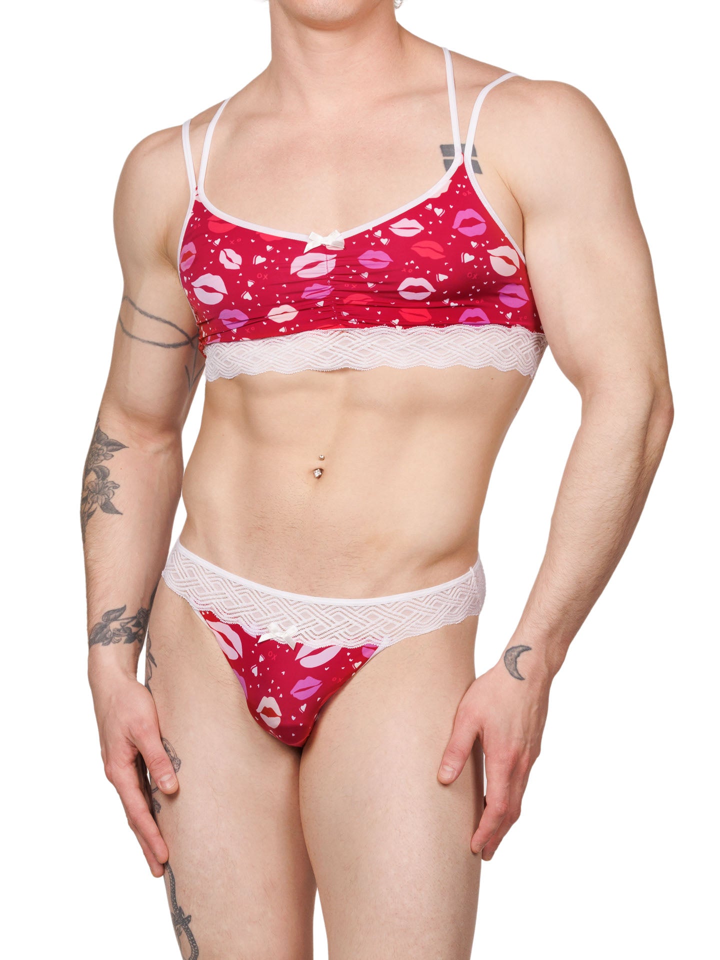 Front view of a male model wearing an XDress matching red and white men's panty and bra with lipstick kisses pattern and lace waistband