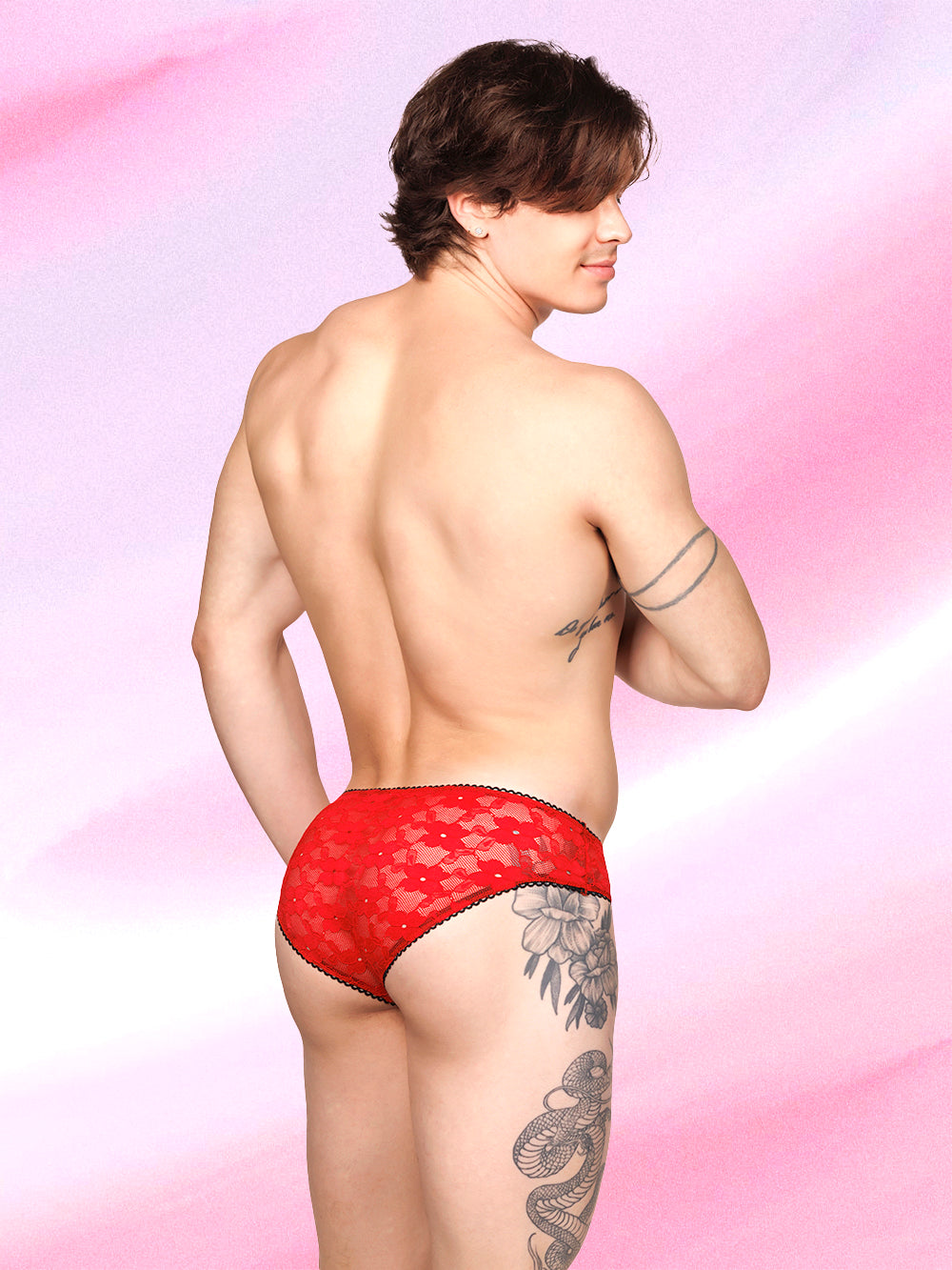 Back view of a male model wearing XDress red lace panties with black picot trim